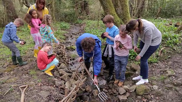 儿童及成人在河上进行保育工作视频素材