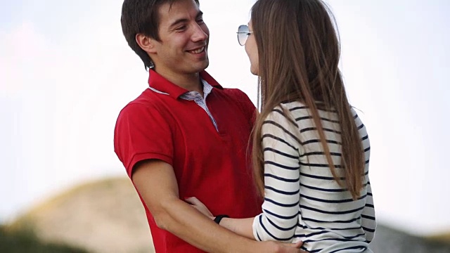 年轻的情侣在山中拥抱、欢笑视频素材
