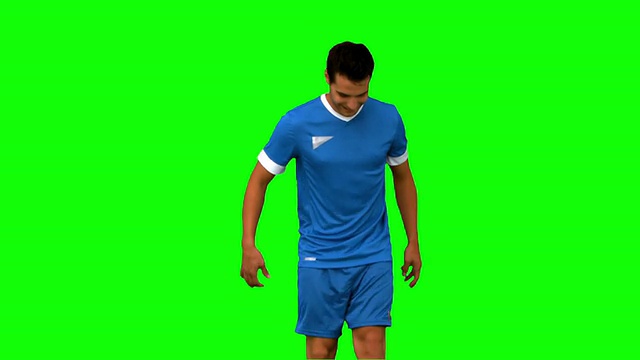 一名男子在绿色屏幕上玩弄足球视频素材