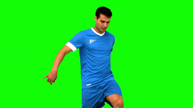 在绿色屏幕上玩足球的帅哥视频素材
