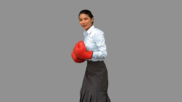 女商人戴着拳击手套打在灰色屏幕上视频下载