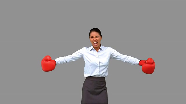 女商人用拳击手套在灰色屏幕上打手势视频下载