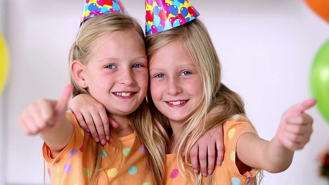 双胞胎姐妹在生日聚会上竖起大拇指视频下载