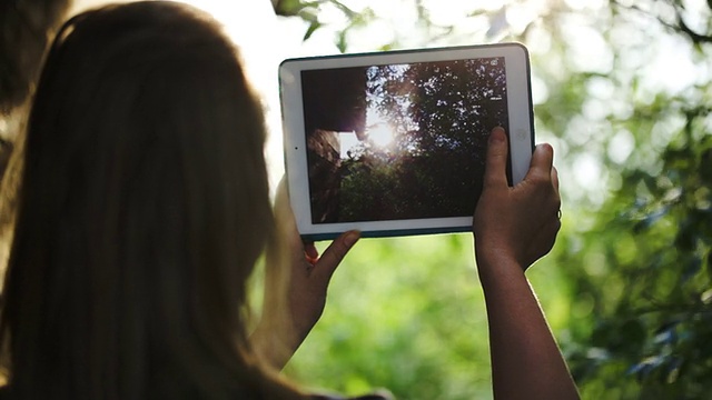 用平板电脑拍自然照片的女人视频素材