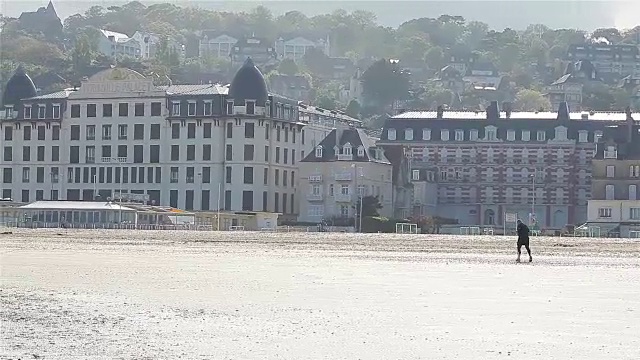 一名男子在欧洲法国特卢维尔海滩上慢跑视频下载