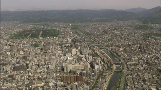 鸟瞰图的京都，日本，揭示了加茂河，城市地区，和遥远的森林山脉。视频素材