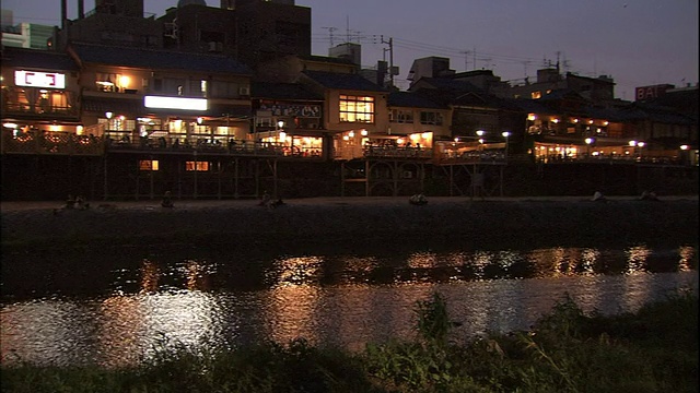 加茂河映照着京都河边餐馆的灯光。视频素材