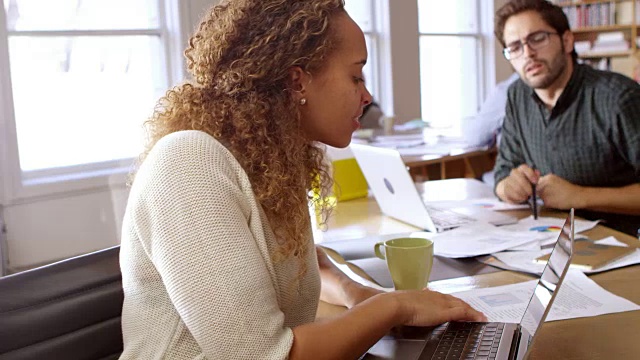 商业女性使用笔记本电脑在办公桌在办公室拍摄的R3D视频素材