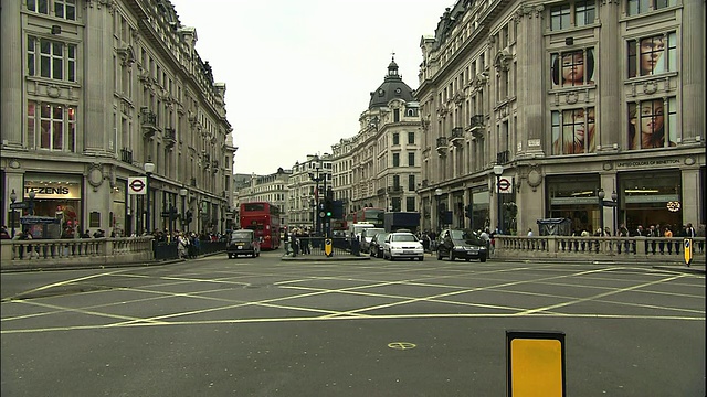 一辆双层公共汽车穿过英国伦敦的牛津广场十字路口。视频素材