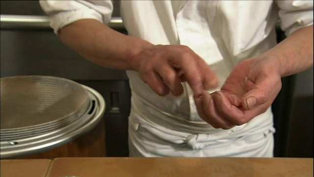 三个厨师把白寿司米饭和薄煎蛋卷卷起来。视频素材