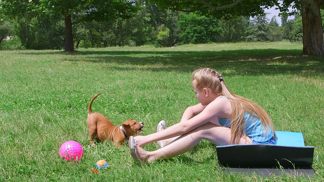 小女孩和小狗在草地上玩视频素材