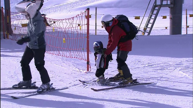 一个小孩踩着滑雪板在雪地上拖着脚走。视频素材