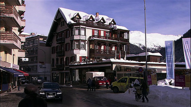 交通和行人穿过冰雪覆盖的瑞士达沃斯山城。视频素材