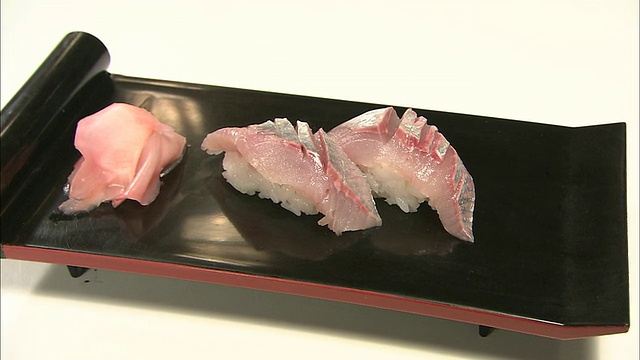 手卷寿司放在木盘上，上面放着鲱鱼片。视频下载