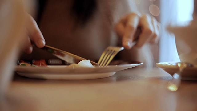 女人在咖啡馆吃蔬菜和肉视频素材