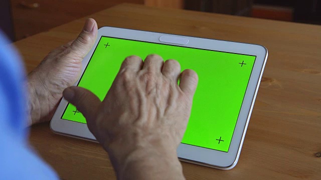 一位上了年纪的男性用手在平板电脑上打字(绿色屏幕)视频下载