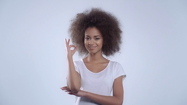 美丽的年轻非洲裔美国女孩显示OK的姿态，孤立在白色的背景。视频下载