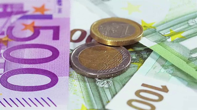 两枚欧元硬币盖过纸币背景视频素材