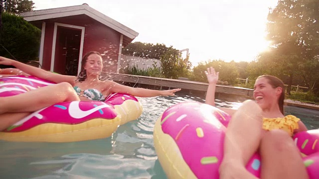 夏天，女孩们在后院的游泳池里嬉戏戏水视频素材