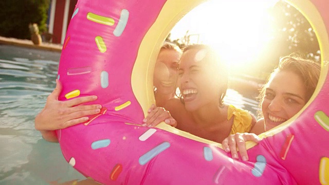 在夏天的下午，女孩们在游泳池里欢笑和玩耍视频素材
