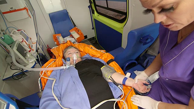 急救人员准备在救护车上给病人静脉输液视频下载