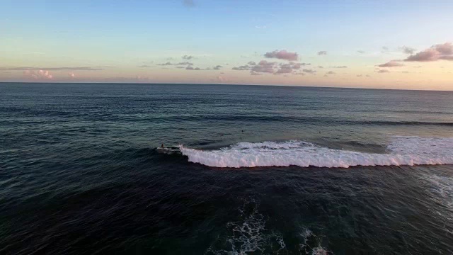 冲浪者在夕阳中乘风破浪(印尼巴厘岛)视频下载