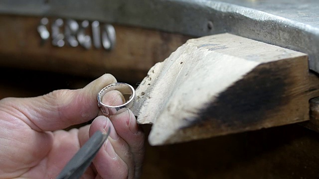 金匠用砂纸和锉刀打磨一个金戒指视频素材