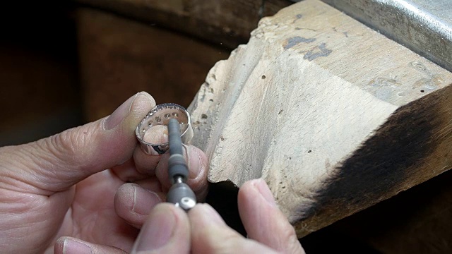 金匠用砂纸和锉刀打磨一个金戒指视频素材