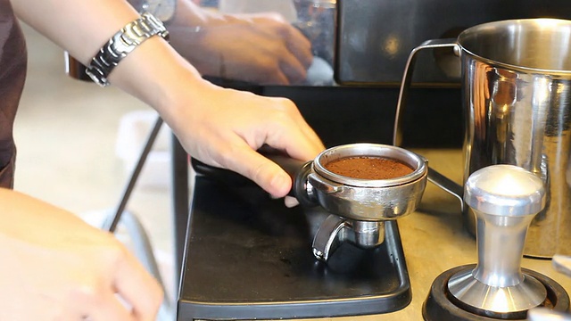 咖啡师捣碎刚磨好的咖啡视频素材