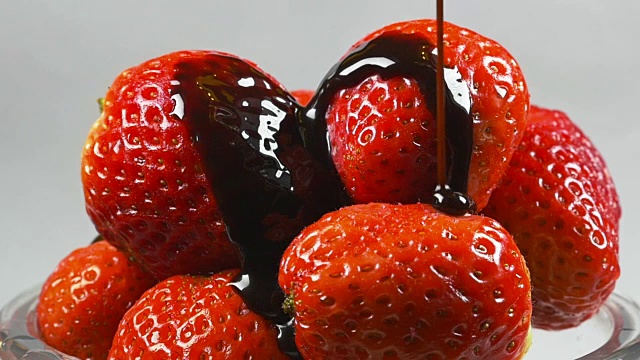 美味融化的巧克力糖浆倒在草莓上视频素材