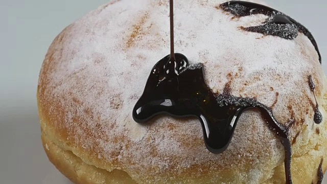 慢镜头中，美味融化的巧克力糖浆倒在甜甜圈上视频素材