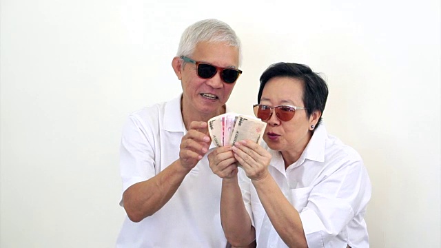 幸福富有的亚洲老年夫妇的视频。中彩票或赌场的现金视频下载