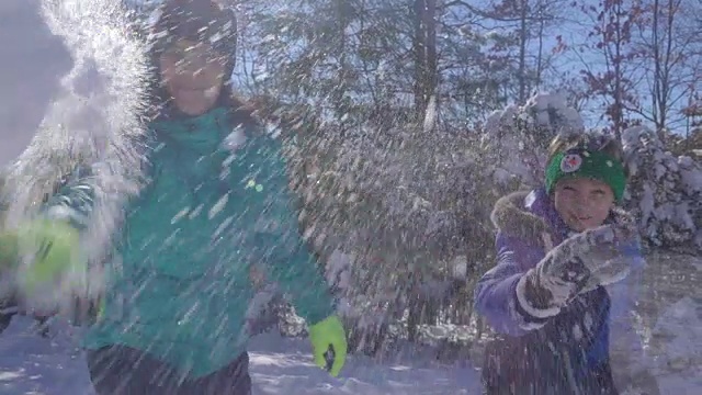 母亲和儿子向照相机扔雪球视频下载