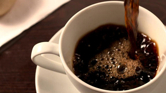 黑咖啡倒入有茶托的杯子里视频下载