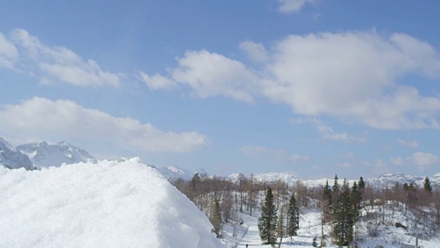 慢动作近距离:滑雪板跳跃大空气踢在阳光明媚的冬天在雪山视频素材