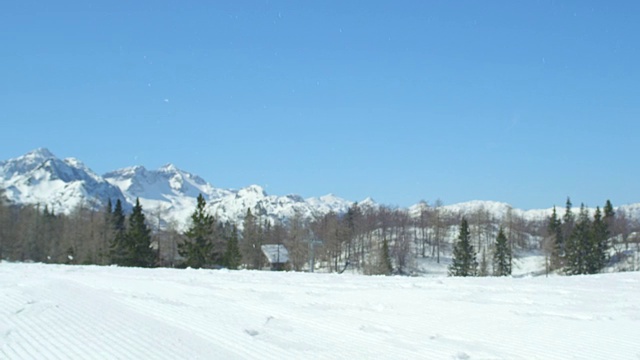 慢镜头特写:滑雪板跳过在一个美丽的阳光明媚的一天在雪上滑雪场的太阳视频素材