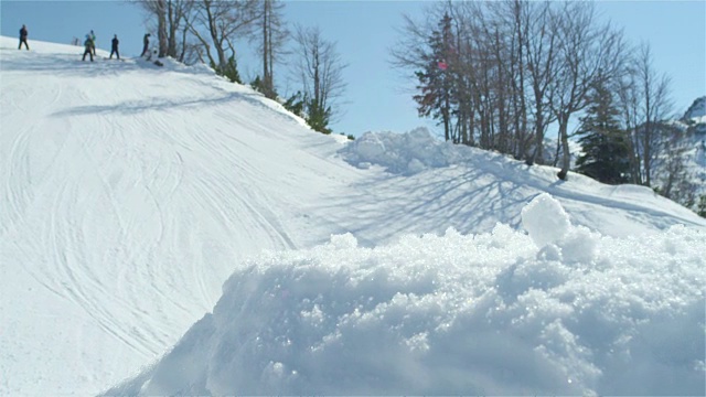 慢镜头特写:职业滑雪板跳跃大空气踢在阳光明媚的冬天在雪山视频素材
