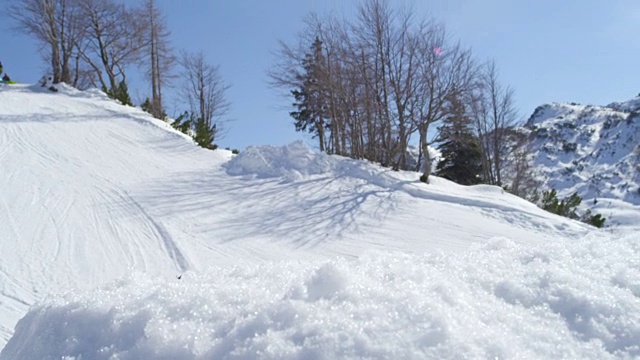 慢镜头特写:滑雪板跳跃大kicker和飞越在雪山的太阳视频素材