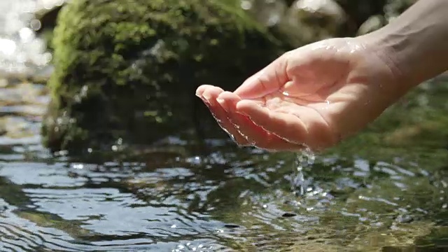慢动作:用手在纯净的山泉中舀淡水视频素材
