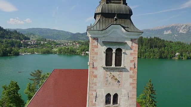 空中近距离观察:在美丽的湖中央的岛屿上环绕着布莱德教堂塔飞行视频下载