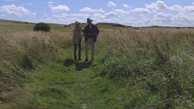 戴双筒望远镜的老夫妇在乡间散步视频素材