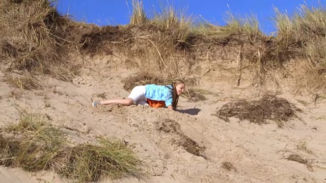 女孩从沙丘上跳下来的慢镜头视频素材