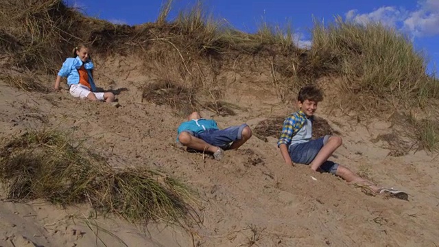 儿童从沙丘上跳下来的慢动作镜头视频下载