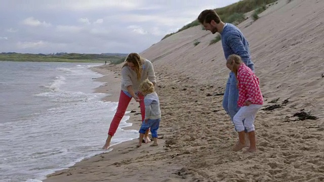 一家人和孩子一起在海边玩海滩度假慢动作视频素材
