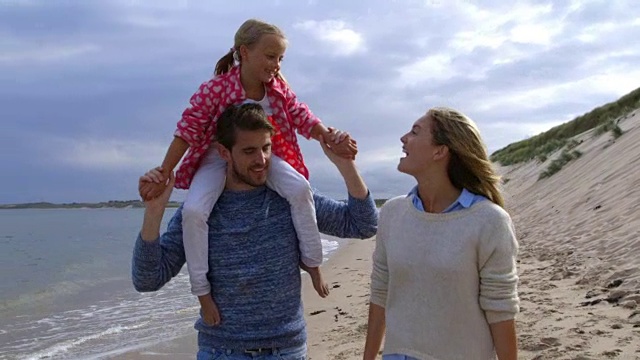 一家人在海边散步，父亲扛着女儿视频下载