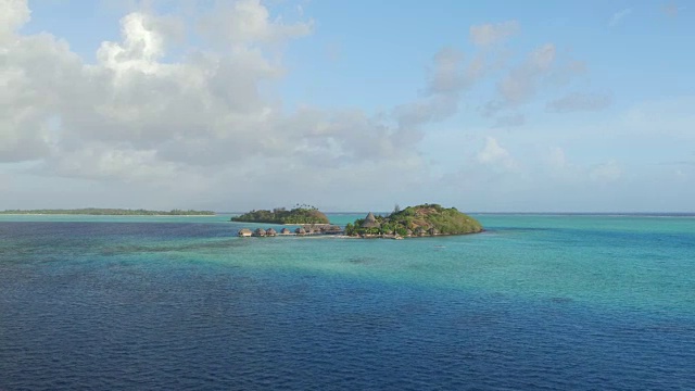 航拍:在美丽的夏日，飞往拥有豪华水上平房的私人岛屿上的完美度假酒店视频素材