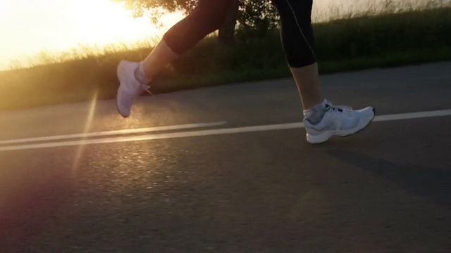 女性跑步者，腿，脚，在日落时跑步，健康活跃视频下载