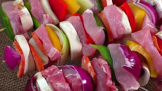准备烧烤的生猪肉串。新鲜准备的彩色肉串，用红、黄、绿的甜椒、洋葱丁串在串上，用胡椒粒调味即可烹制视频下载