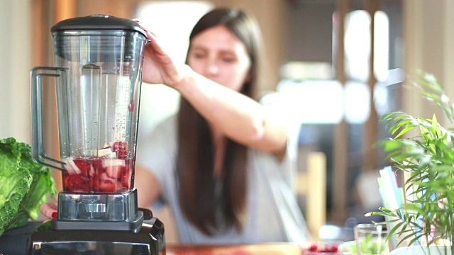 用搅拌机拌水果的女人视频素材