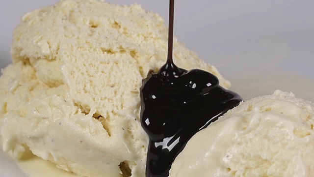 将美味的巧克力糖浆倒在冰淇淋上视频素材